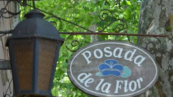 Une enseigne portant l’inscription « Posada de la Flor » est suspendue à une structure métallique.