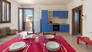 A dining area with a red tablecloth, blue cabinets, and a view of the outside. - L'Agrumeto (Diso)