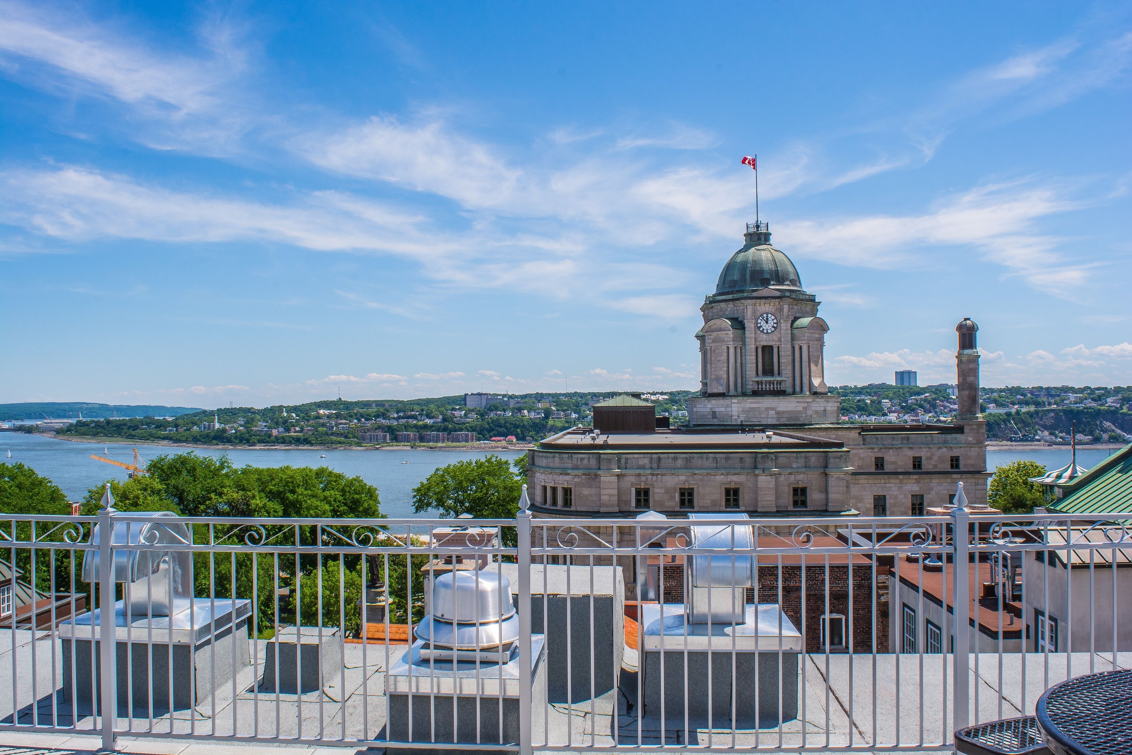 A view of a historic building with a clock tower, overlooking a body of water and a cityscape.