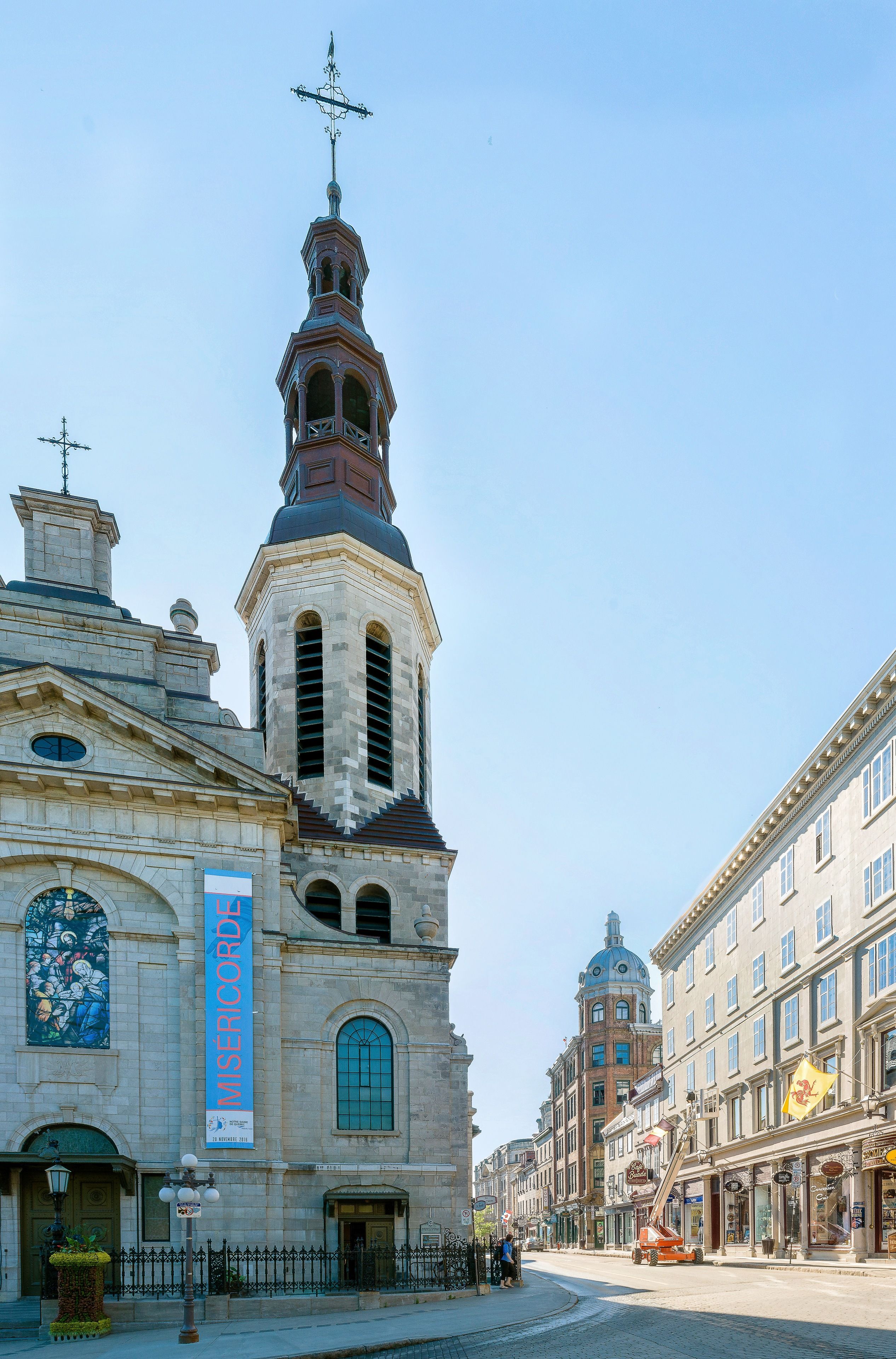 A historic building with a prominent tower, large windows, and a banner.