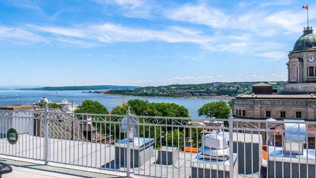 Vista elevada de un paisaje urbano con un río, edificios históricos y una torre del reloj.