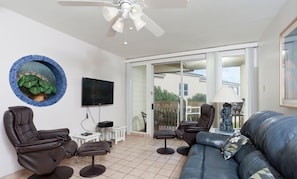 A living room with a sofa, two armchairs, a coffee table, a television, and a ceiling fan. - Bahia Mar by Padre Island Rentals (South Padre Island)