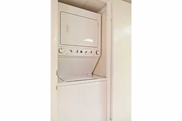 Une buanderie blanche équipée d’un lave-linge et d’un sèche-linge encastrés.