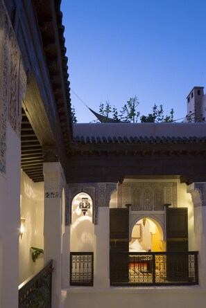 A traditional courtyard with ornate arches and a balcony with a wrought iron railing. - Riad Assala (Marrakech)