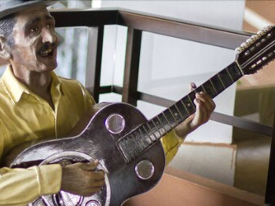 Estátua de uma pessoa tocando violão.