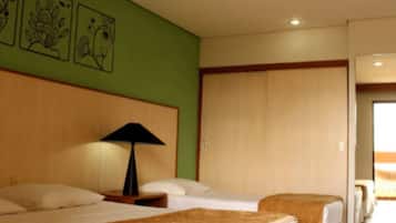 Une chambre d’hôtel avec deux lits, une tête de lit en bois, une table de chevet avec une lampe et des œuvres d’art accrochées au mur.