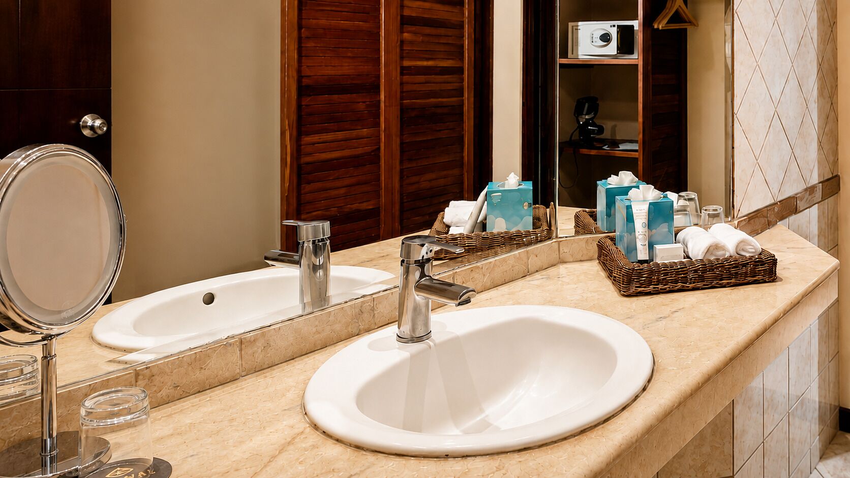 A bathroom with two sinks, a mirror, and toiletries.