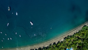 Vue aérienne d’une zone côtière avec des bateaux et une plage.
