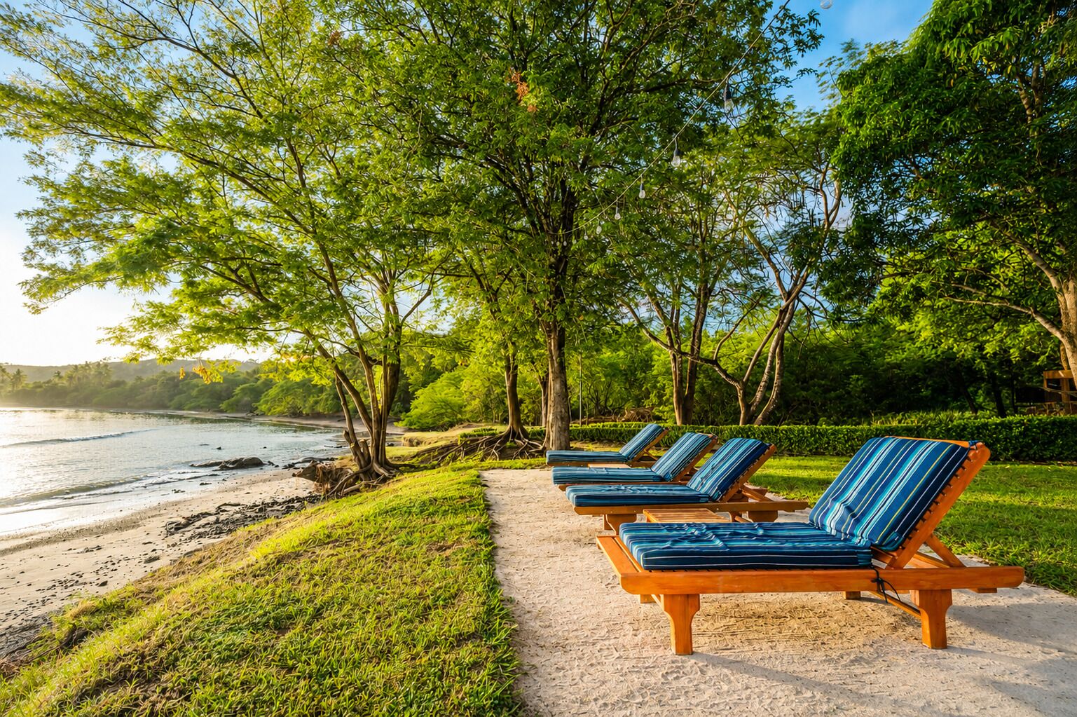 A beachside lounge area with sun loungers and a path leading to the water.