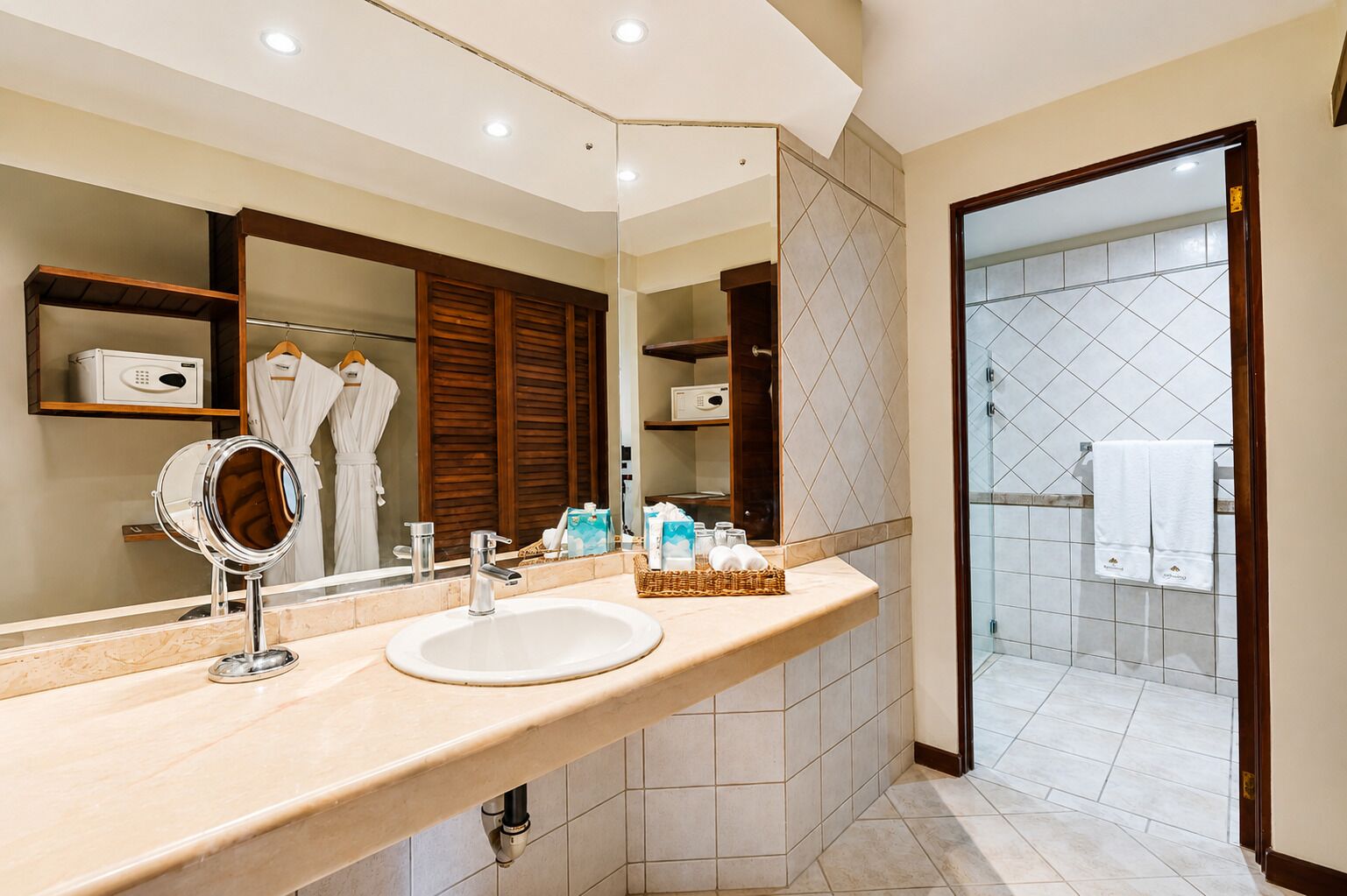 A modern bathroom with a vanity, a large mirror, and a shower area.