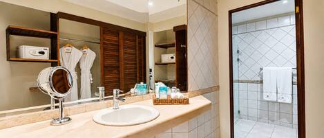 A modern bathroom with a vanity, a large mirror, and a shower area.