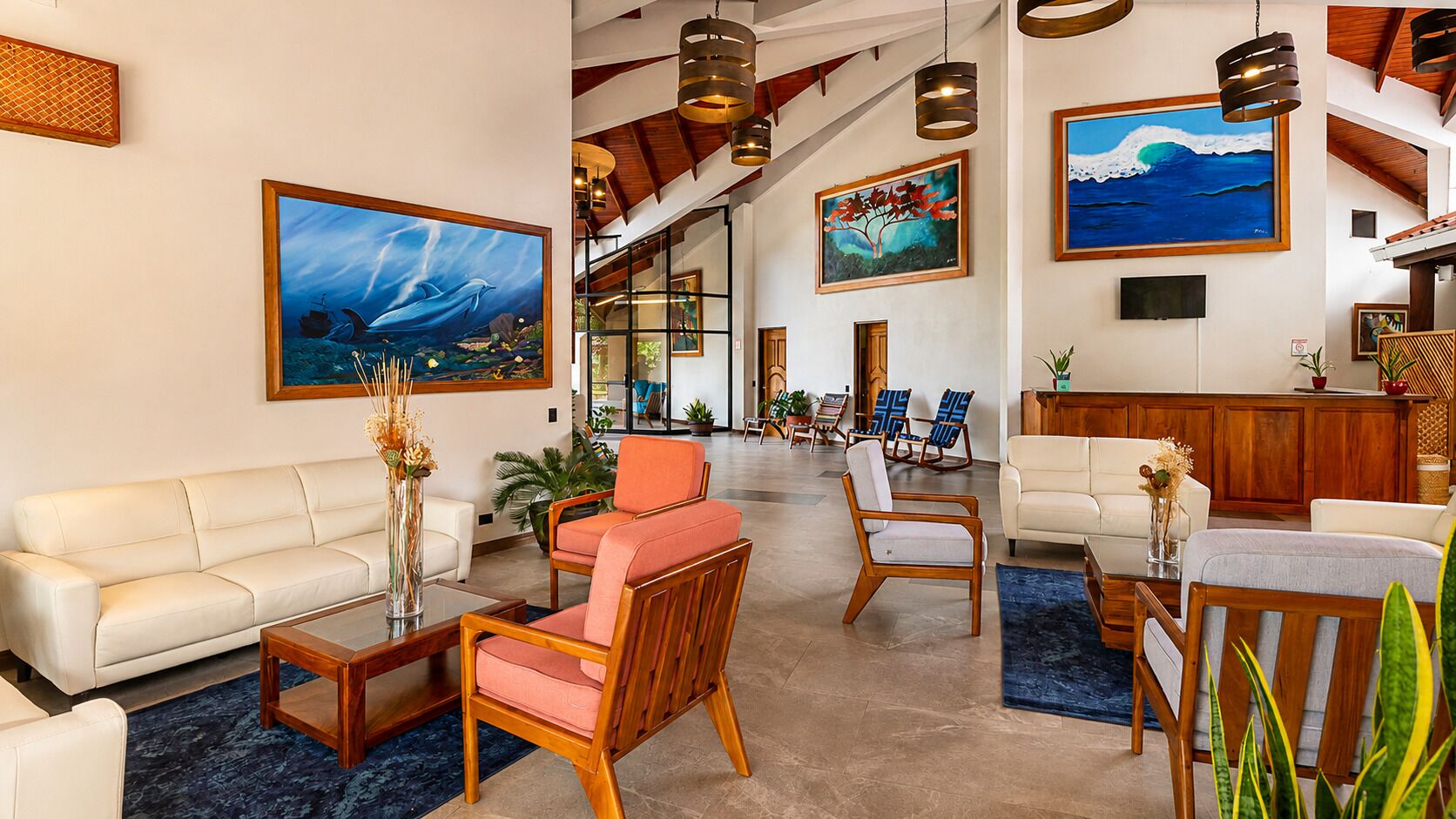 A spacious lobby with a sofa, chairs, a coffee table, and artwork on the walls.