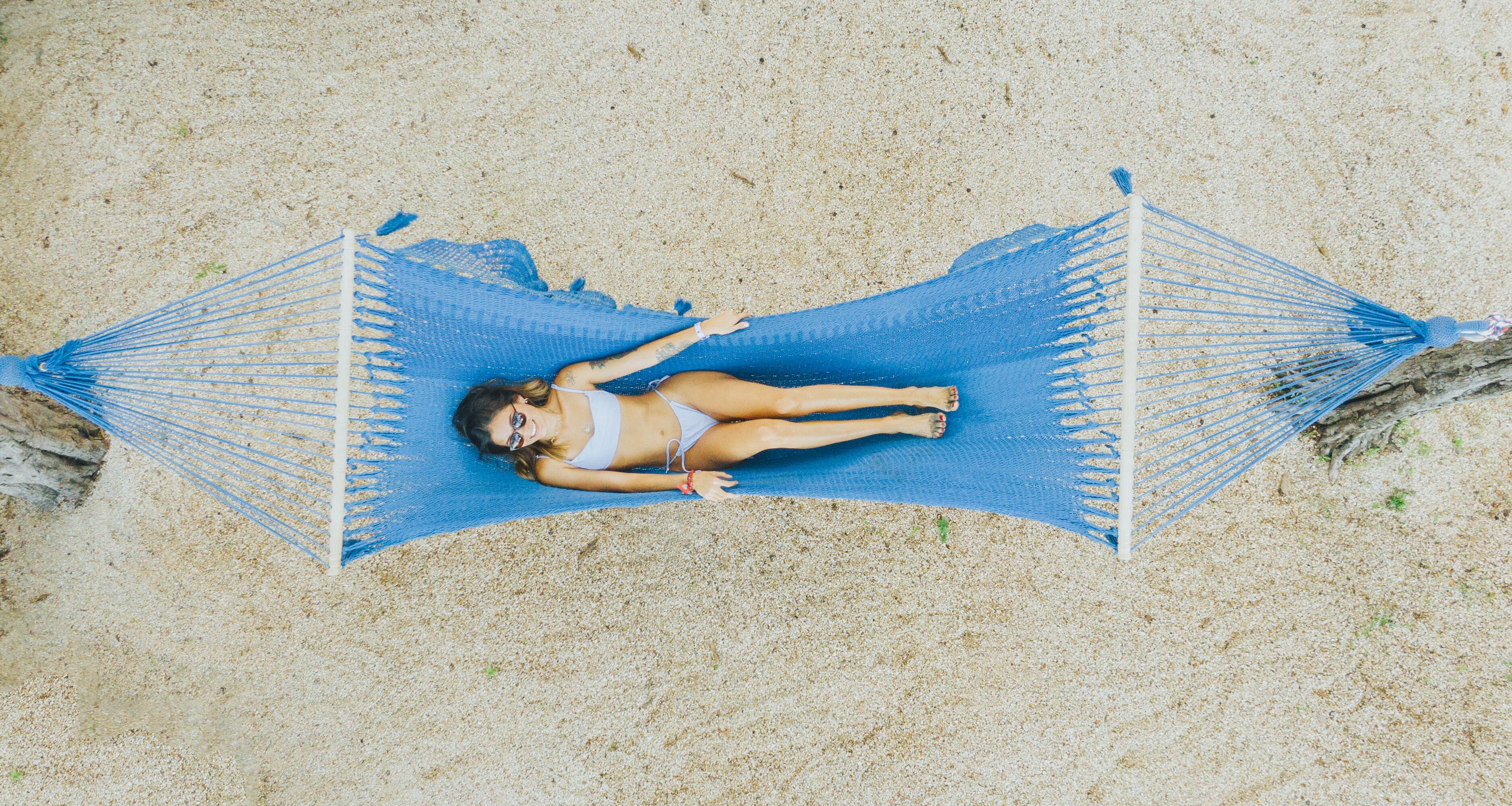 A hammock on a sandy beach.