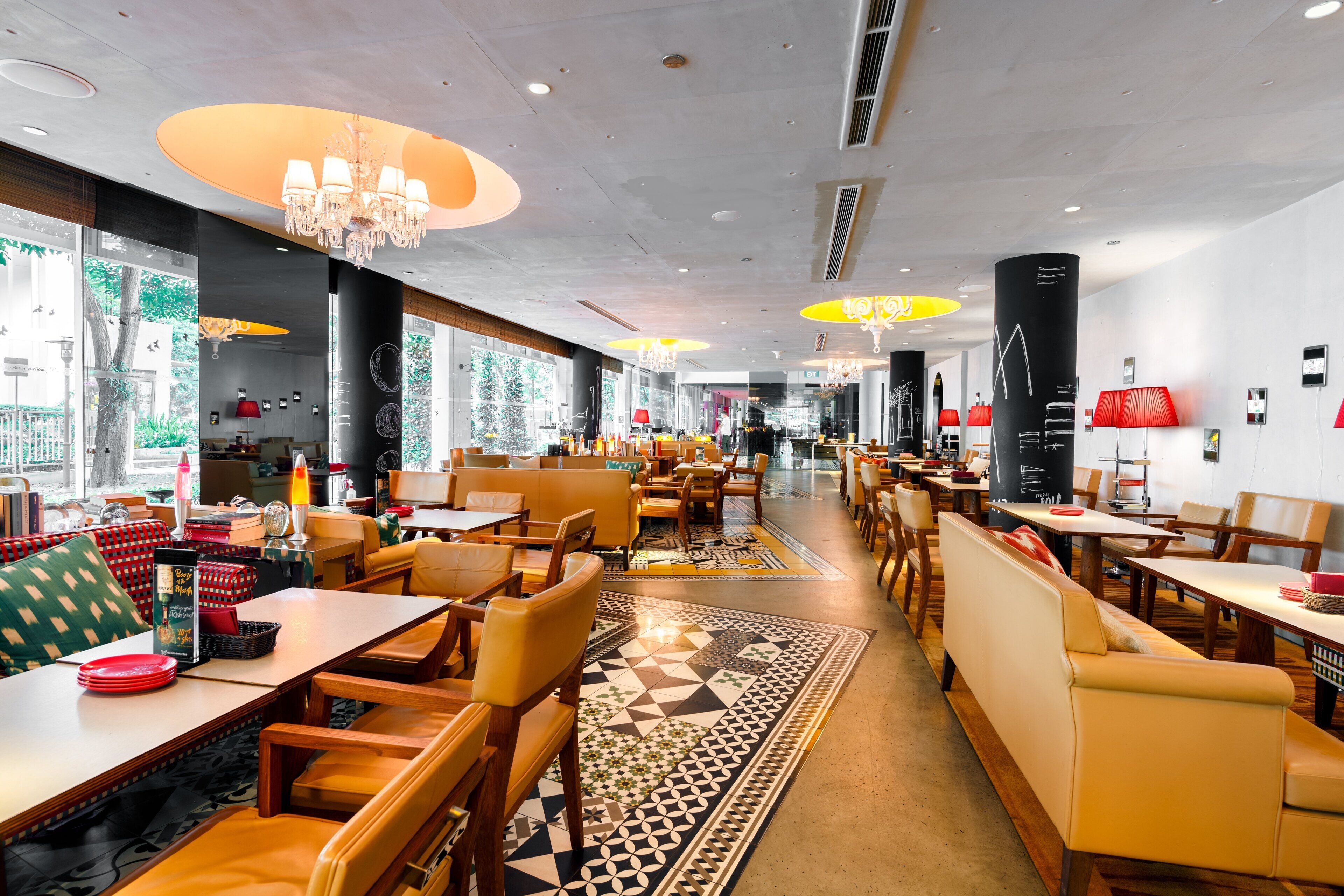 A spacious restaurant with high ceilings, chandeliers, and a variety of seating options including booths and tables.