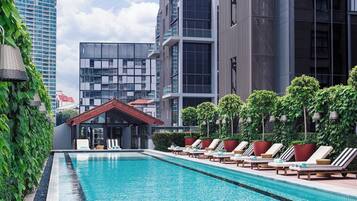 Una piscina al aire libre, tumbonas