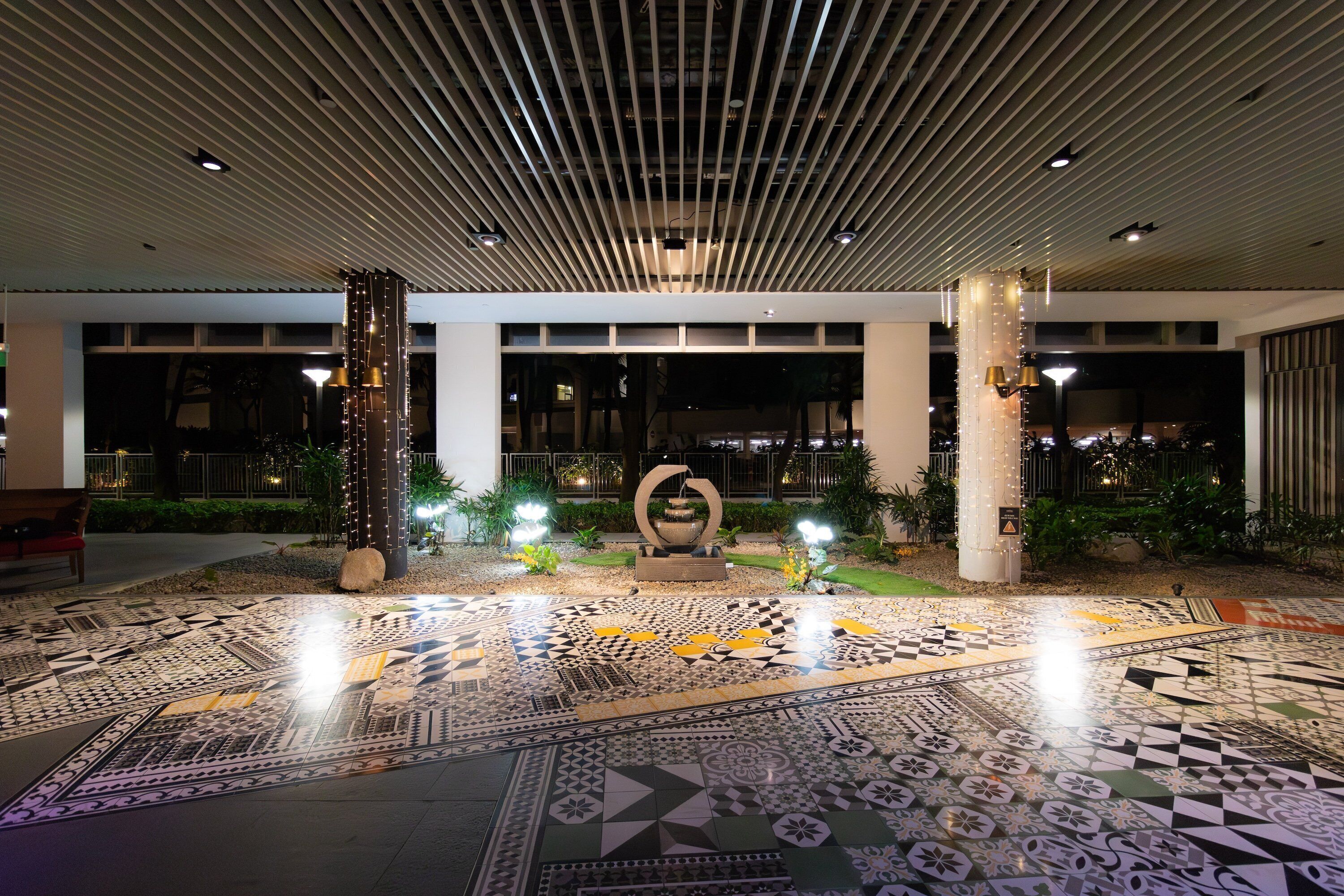 A spacious lobby with a patterned floor, modern ceiling design, and decorative lighting.