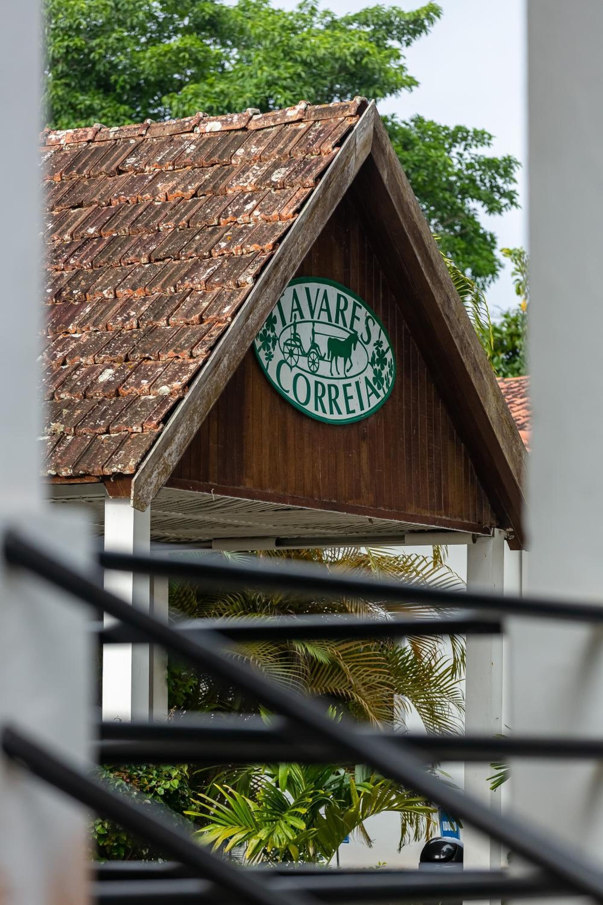 A building with a sign reading "AVARE'S CORREIA" on a wooden structure with a tiled roof.