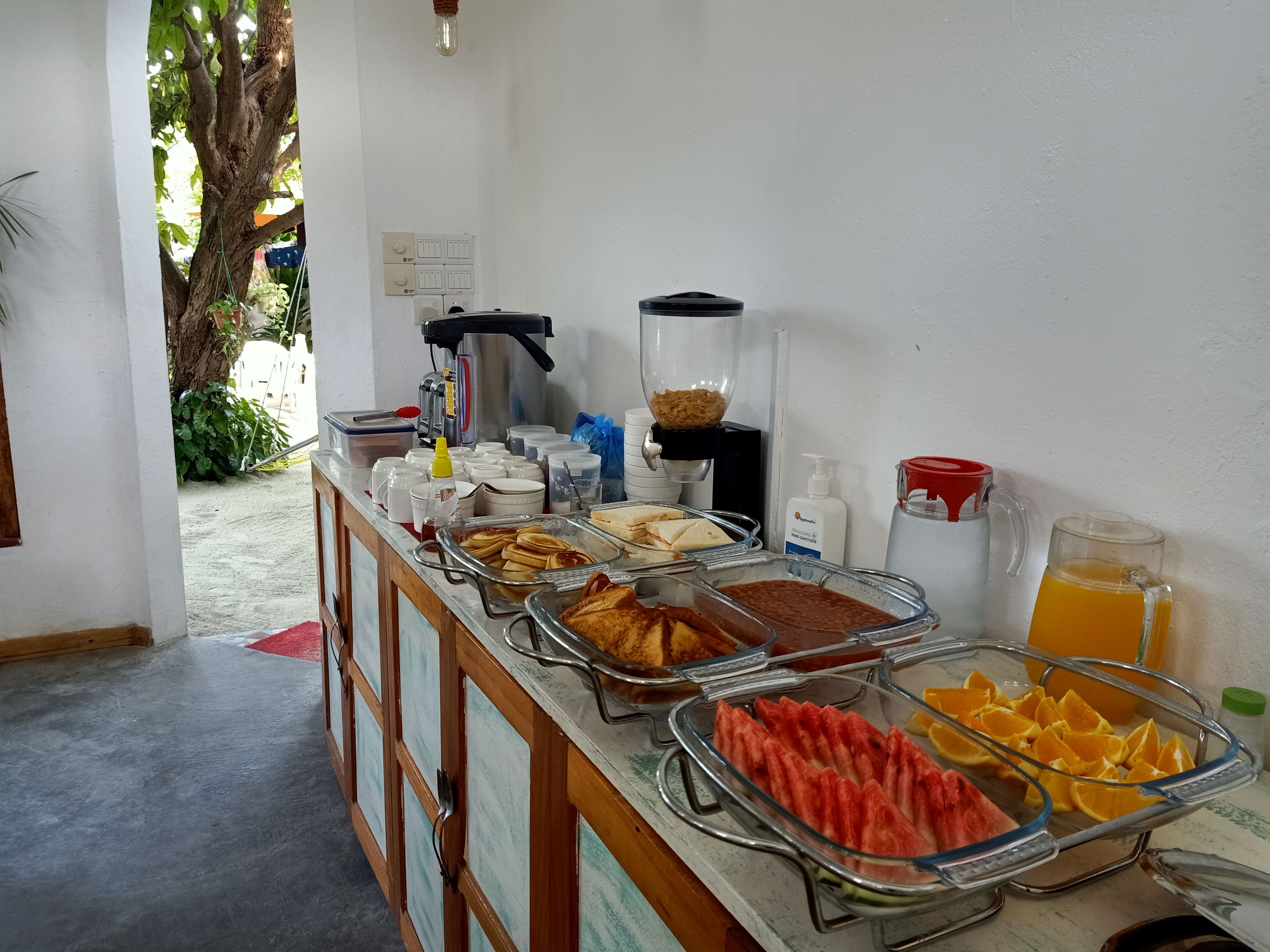A buffet setup with various food items and a coffee machine.