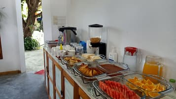 A buffet setup with various food items and a coffee machine.