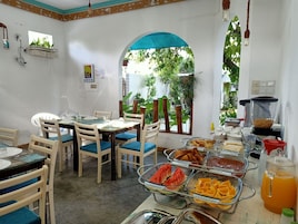 Un comedor con barra de buffet, que incluye diversos alimentos y un dispensador de bebidas.