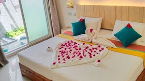 Una habitación de hotel con una cama de madera, un ventanal grande y una pared decorada con figuras de animales de madera.
