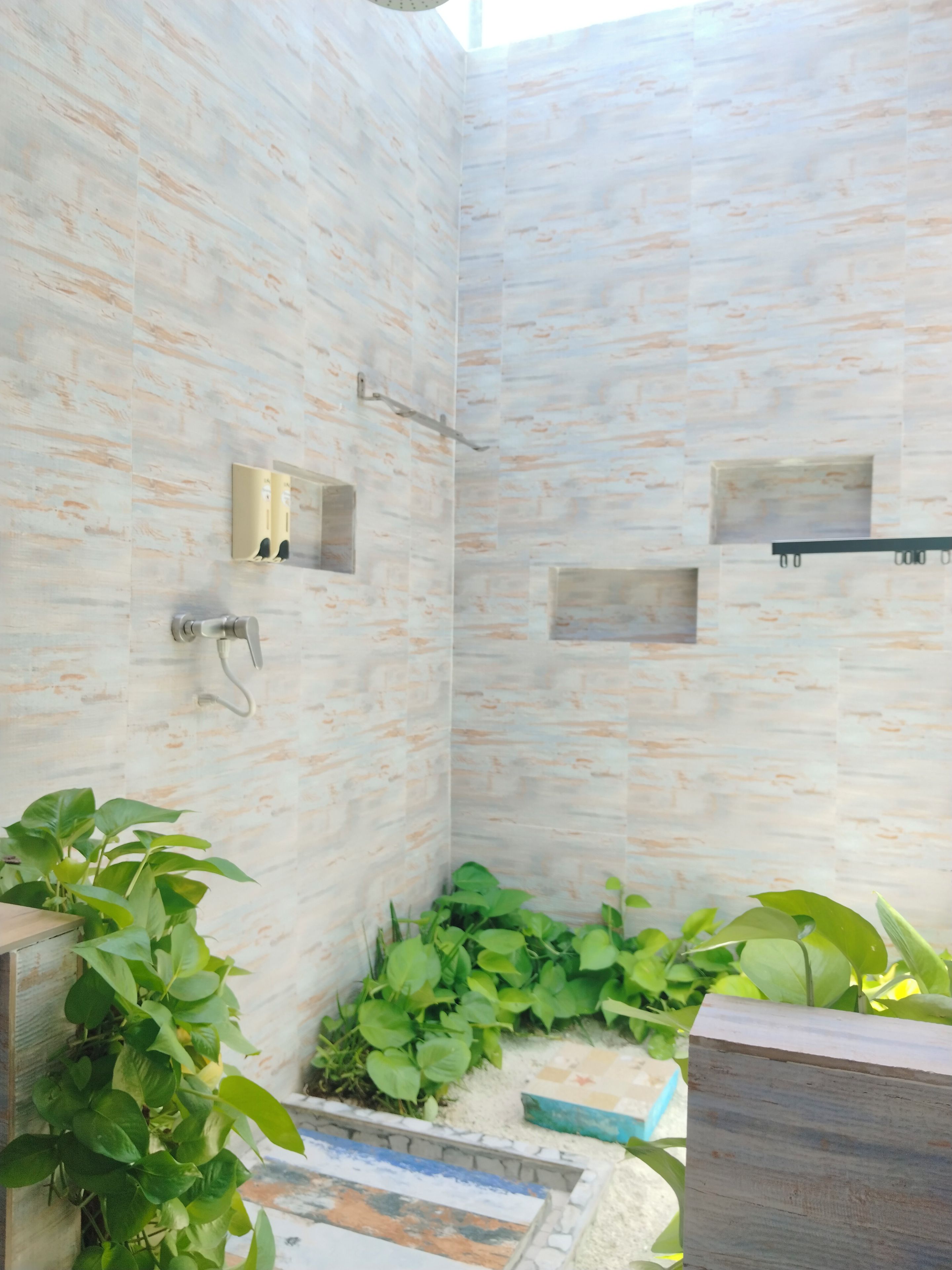 Une salle de bain moderne équipée d’une douche, d’un miroir et d’étagères intégrées.