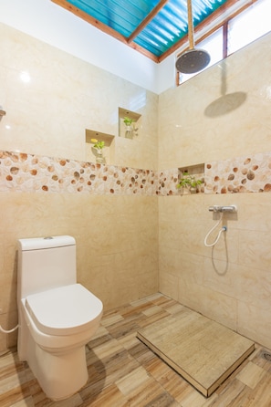 A modern bathroom with a toilet, shower, and decorative tiles. - Dream Inn Sun Beach Hotel (Thulusdhoo Island)