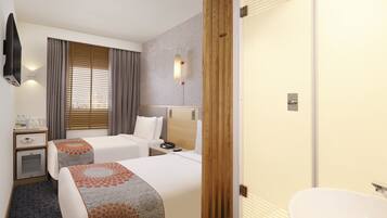 Habitación de hotel con dos camas, una mesita de noche con lámpara, un armario y un baño con lavamanos e inodoro.