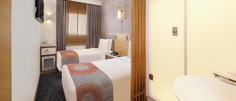 A hotel room with two beds, a desk, a minibar, a bathroom with a toilet and sink, and a window with blinds.