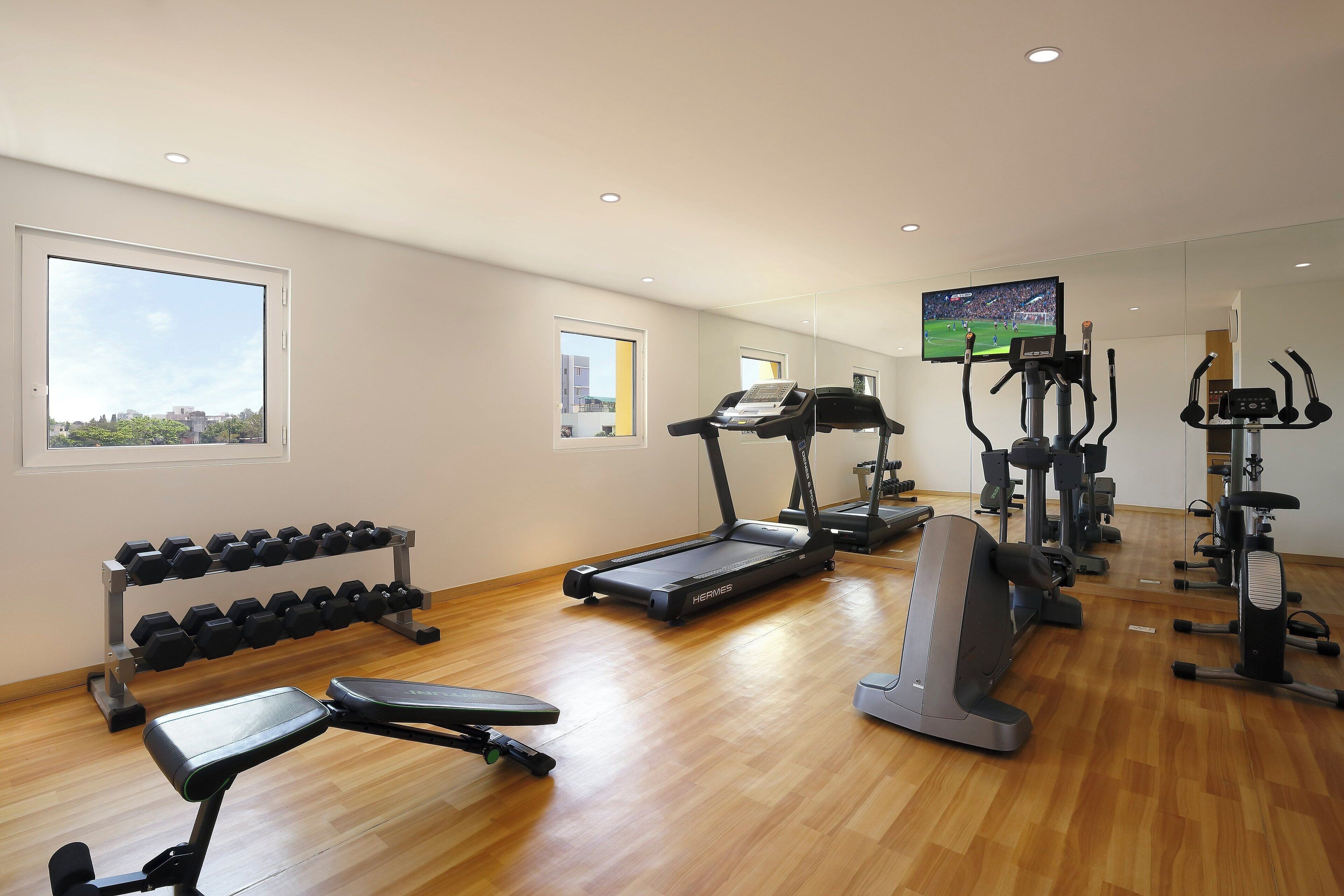 Un gimnasio con cintas de correr, elípticas y pesas.