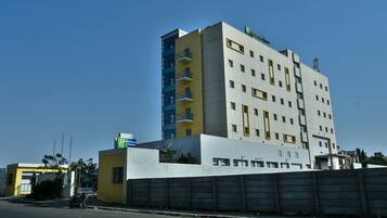A multi-story hotel with a yellow and white facade, several balconies, and a sign indicating it is a Holiday Inn Express.