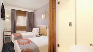 A hotel room with two beds, a bedside table, a minibar, a shower area, and a bathroom with a toilet and sink.