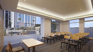 Une salle de conférence dotée d’un sol recouvert de moquette, de chaises en bois et d’une table.