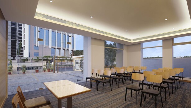 A conference room with a carpeted floor, wooden chairs, and a table. - Holiday Inn Express Nashik Indira Nagar by IHG (Nashik)