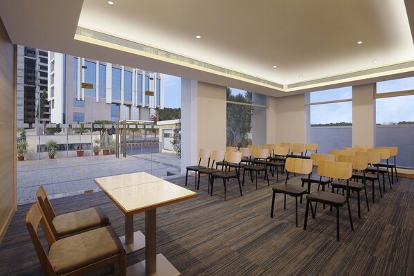 A conference room with a carpeted floor, wooden chairs, and a table. - Holiday Inn Express Nashik Indira Nagar by IHG (Nashik)