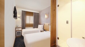 Une chambre d’hôtel avec deux lits, un bureau, un minibar, une télévision et une salle de bain.