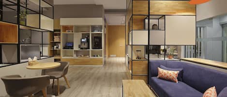 A modern living room with a sofa, chairs, a small table, and built-in shelving with various items.