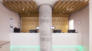 A reception area with a central pillar, two reception desks, and a patterned floor. - Ibis Styles London Heathrow (West Drayton)