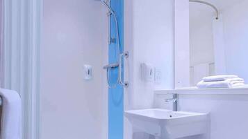 A modern bathroom with a shower, sink, and toilet.