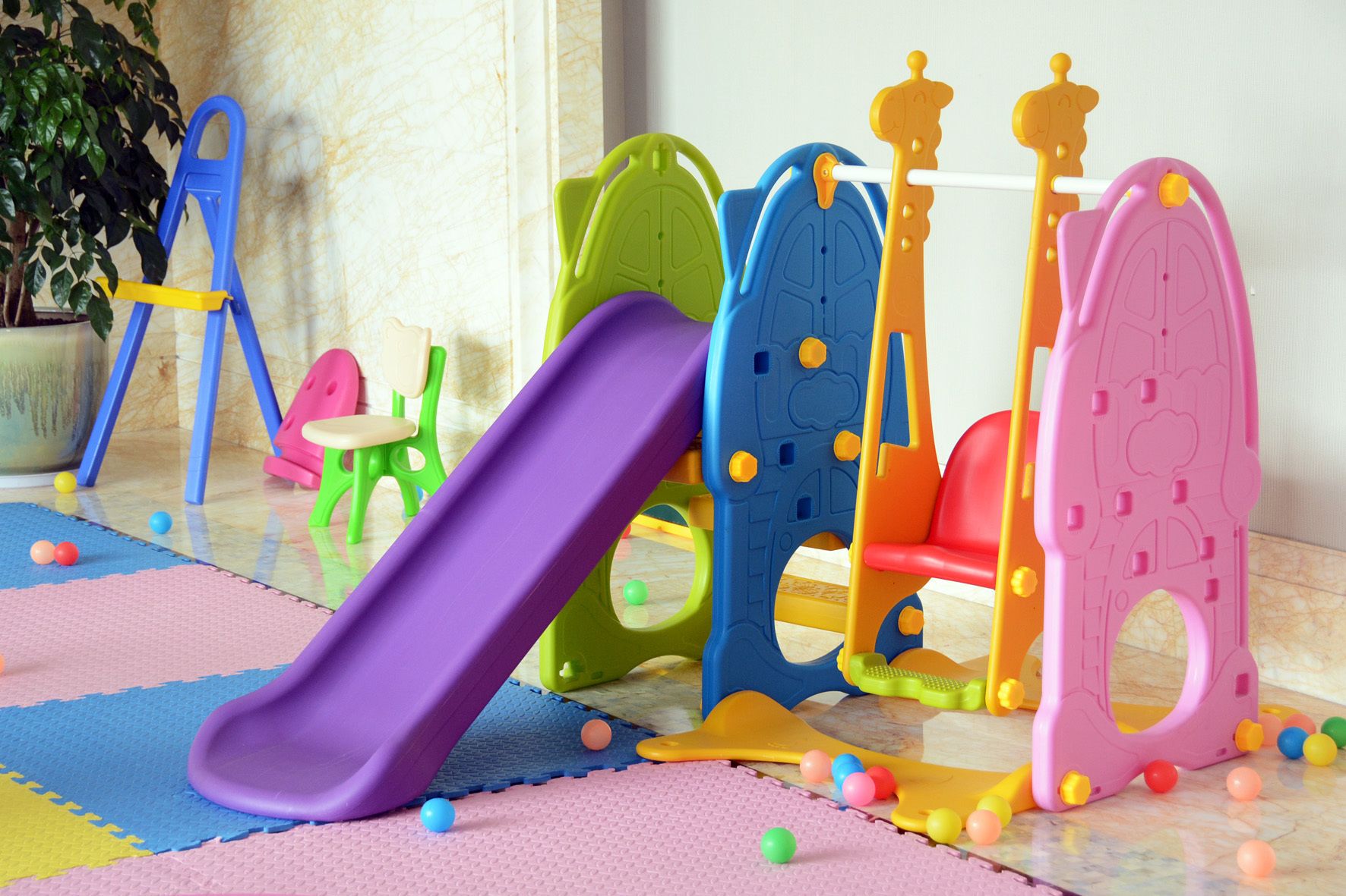A play area with colorful play structures and a purple slide.