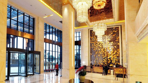 A spacious lobby with large windows, a central round table with a vase, and a grand chandelier. - Wyndham Grand Plaza Royale Mingfa Zhangzhou (Zhangzhou)