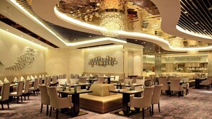 A spacious hotel lobby with multiple dining tables and chairs, a central seating area, and a decorative ceiling. - Wyndham Grand Plaza Royale Mingfa Zhangzhou (Zhangzhou)