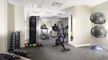 A gym with exercise equipment, a treadmill, and a mirror.