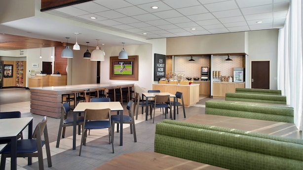 A modern restaurant with a bar area, green cushioned seating, and a sports screen. - Fairfield Inn & Suites by Marriott Asheville Airport/Fletcher (Fletcher)