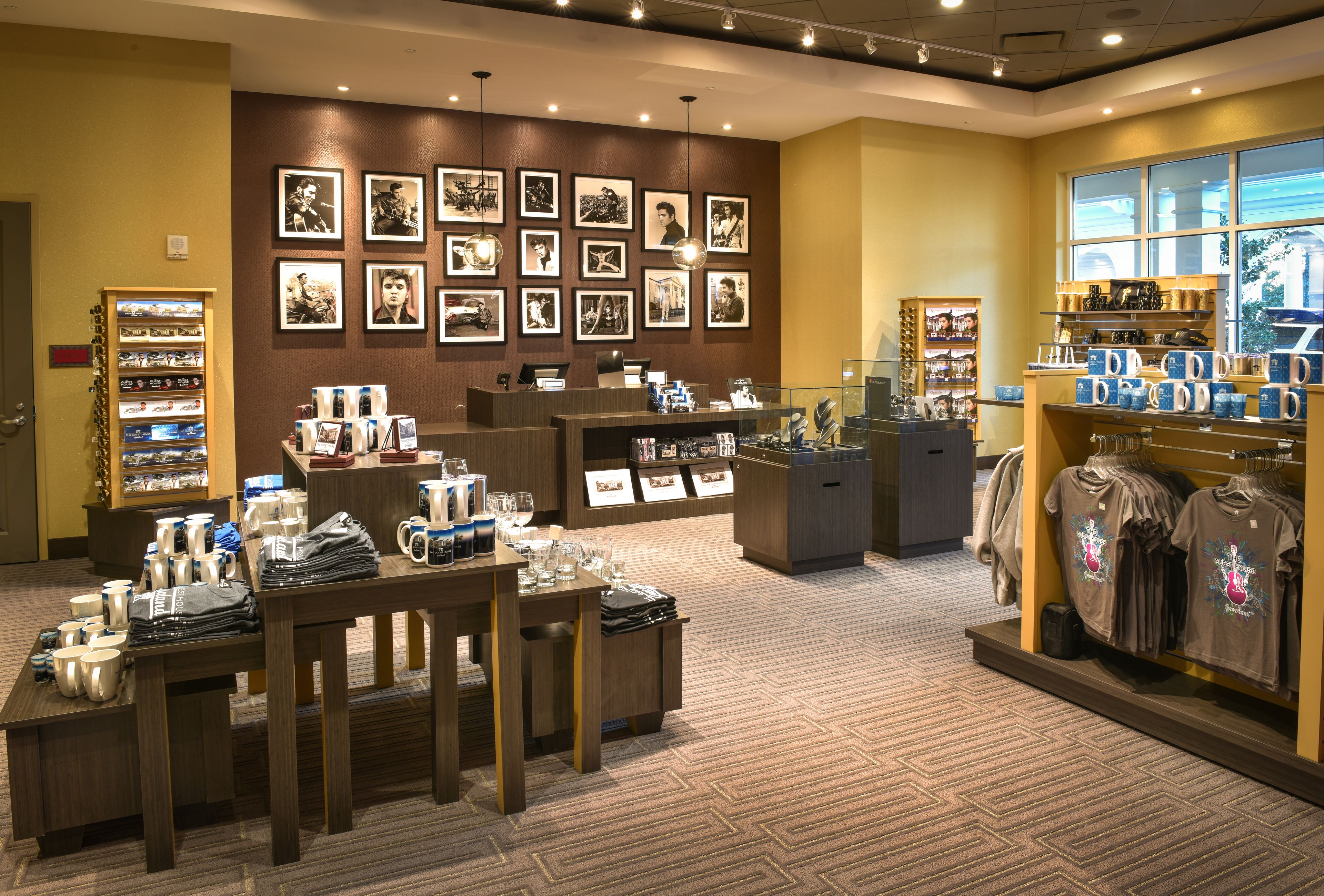 Un magasin de détail où sont exposés divers articles, notamment des tasses, des verres et des vêtements.