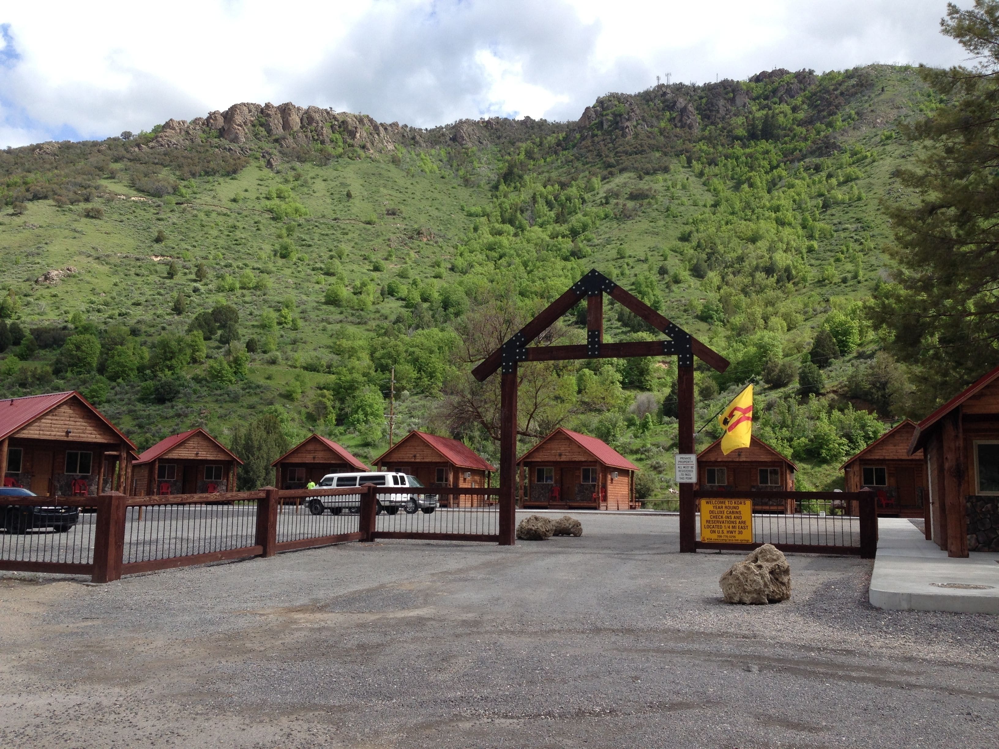 A rustic lodge with wooden cabins and a mountain backdrop.