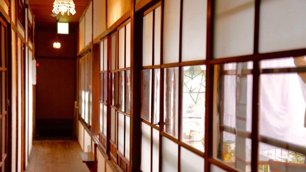 A corridor with traditional wooden sliding doors and a wooden floor. - Ise Guesthouse Tsumugiya - Hostel (Ise)