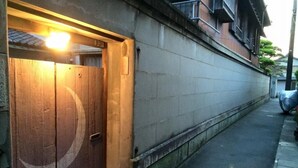 A narrow alleyway with a wooden door and a concrete wall. - Ise Guesthouse Tsumugiya - Hostel (Ise)