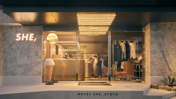 The entrance of Hotel She, Kyoto, featuring a modern design with marble walls, a visible ice cream shop sign, and a clothing store. - HOTEL SHE, KYOTO (Kyoto)