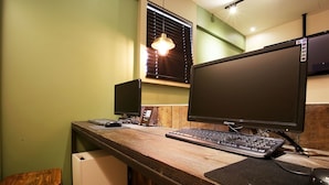 A wooden desk with two monitors, a keyboard, and a mouse. - Achasan Station Wall Hotel (Seoul)